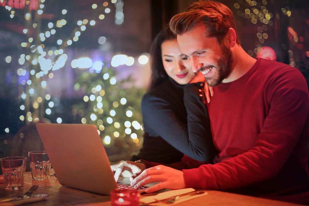 Couple comparing wedding registry options on a laptop