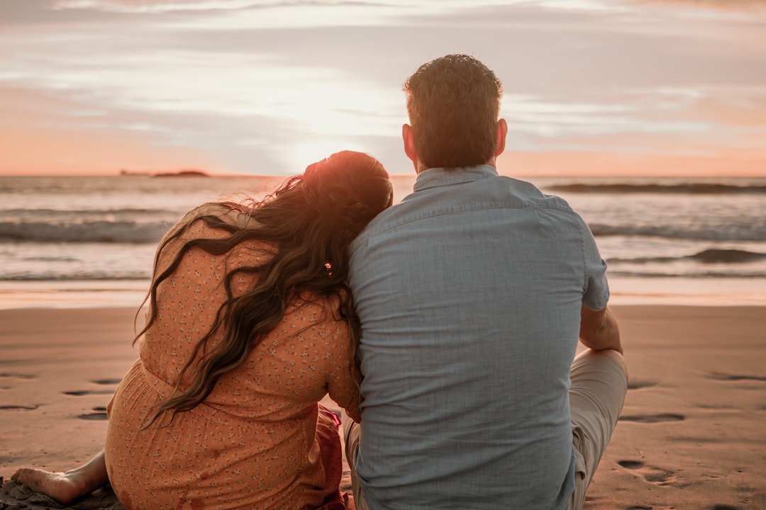 Newlyweds relaxing on a tropical beach with clear blue water