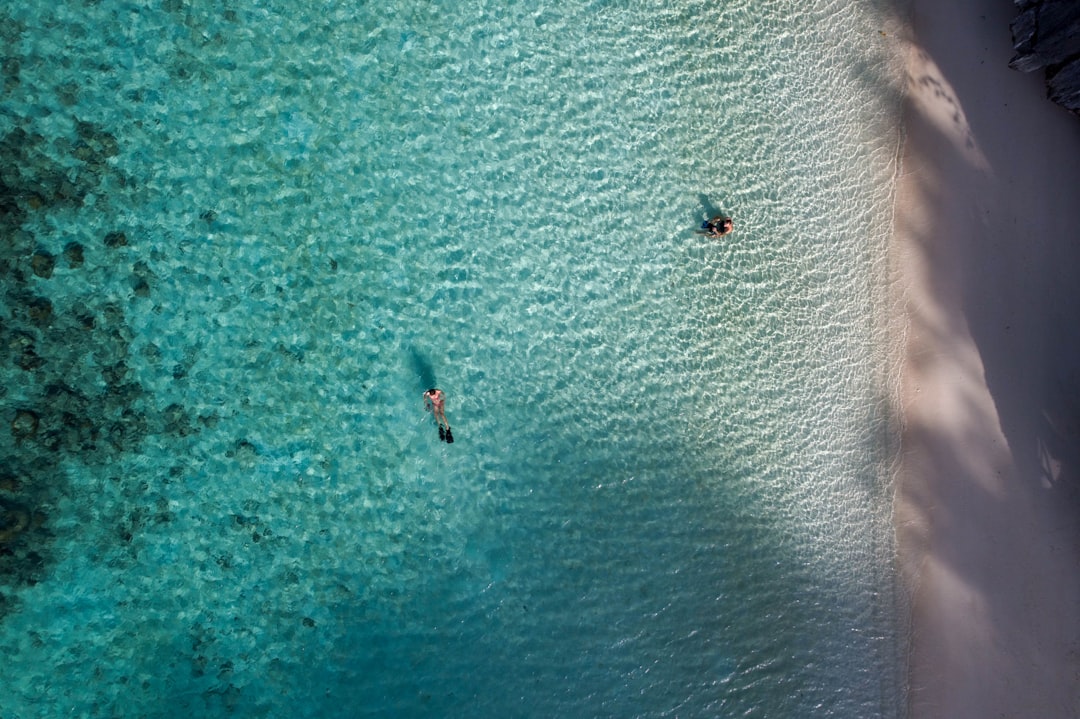 Couple snorkeling together above a vibrant coral reef in the Maldives