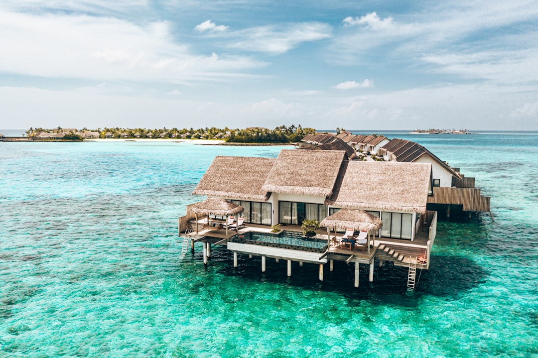 Luxury overwater villa with private infinity pool at sunset
